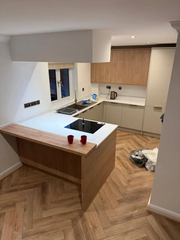 A modern kitchen with white counters and an integrated hob.