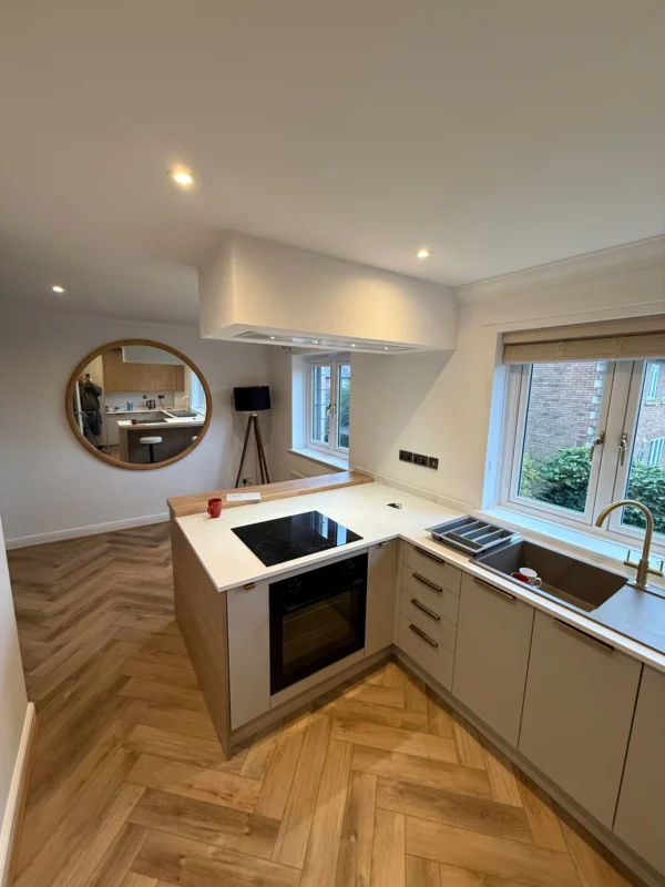 A contemporary kitchen with a large round mirror.