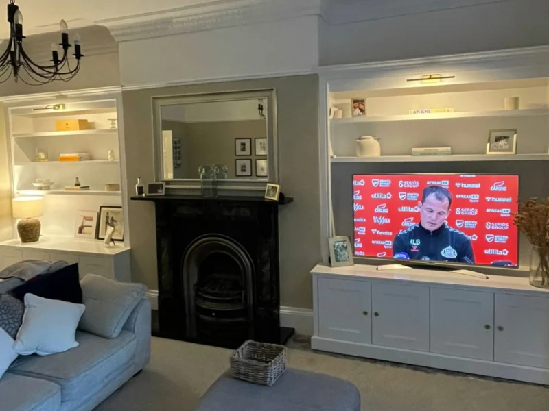 A living room with a large fireplace and neutral colour palette.