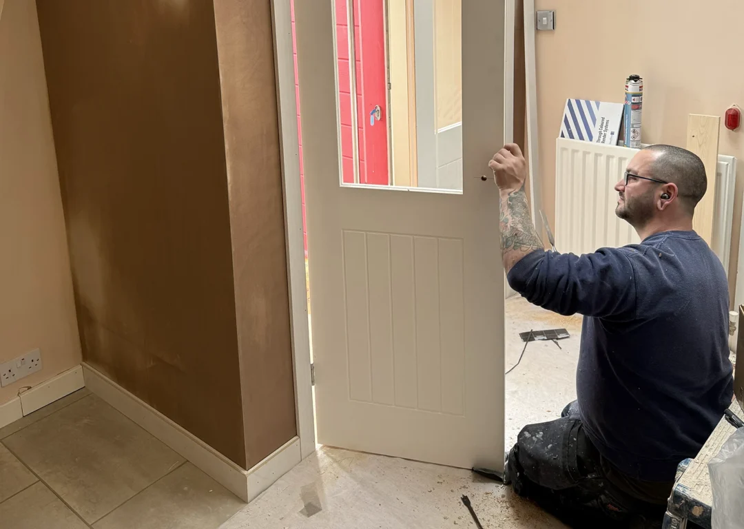 Langdale Projects worker fitting a door ina property renovation.