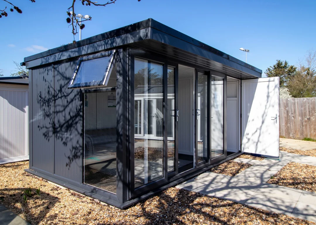 A small garden office featuring a sliding door, with minimal furniture and neutral-colored walls.