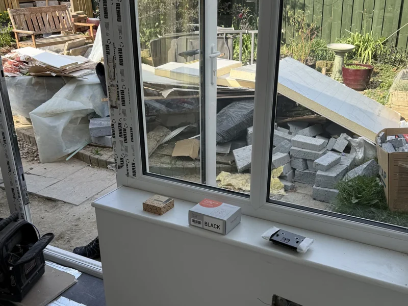 An electrical fitting in a room renovation with a large window letting in natural light.