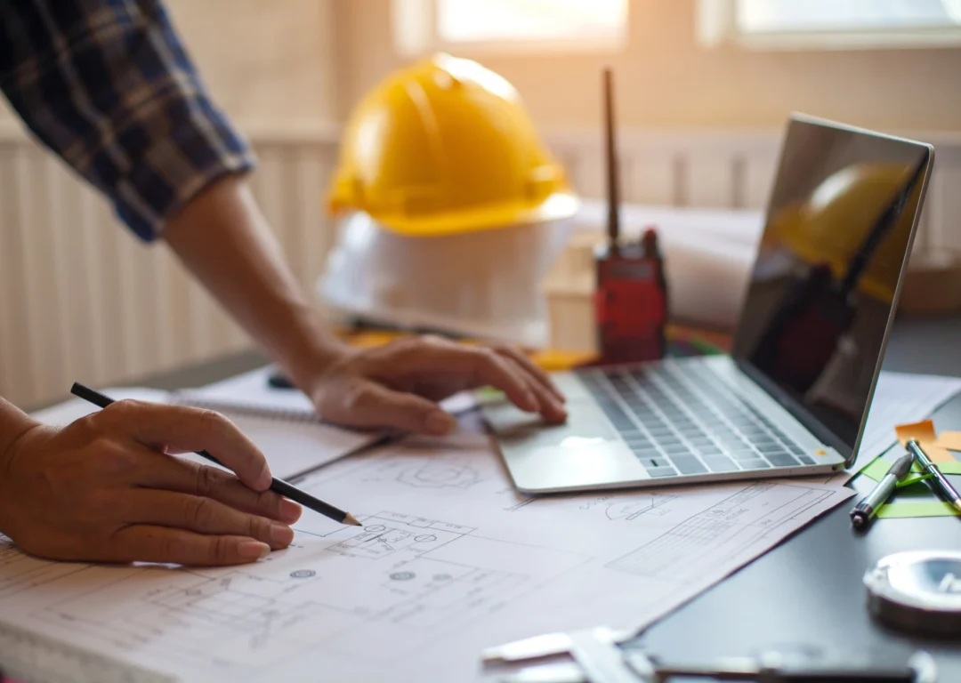 A man makes notes on house blueprints.